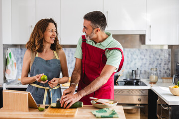 Caucasian mature couple in the kitchen preparing vegetable healthy food