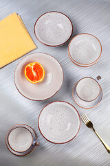 Ceramic bowls and cups are laid out on the table.