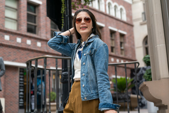 modern millennial lady is looking into distance from a high place, background red brick building