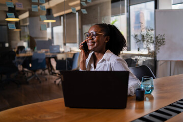 Black businesswoman working on laptop. Portrait of beautiful businesswoman in the office. Woman...