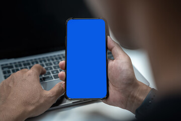 Man holding smartphone with blank screen, close-up of hands. Space for text.