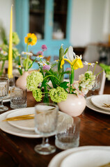 serving the table with fresh flowers and candles