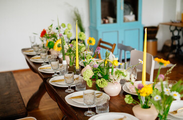 serving the table with fresh flowers and candles