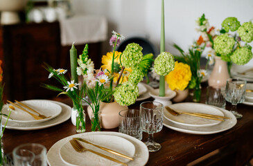 serving the table with fresh flowers and candles