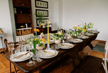 serving the table with fresh flowers and candles