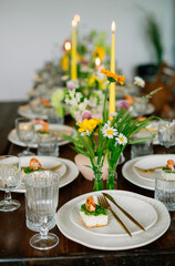 serving the table with fresh flowers and candles