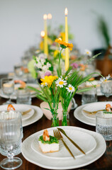 serving the table with fresh flowers and candles