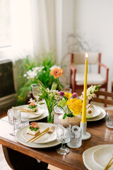 serving the table with fresh flowers and candles