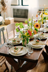 serving the table with fresh flowers and candles