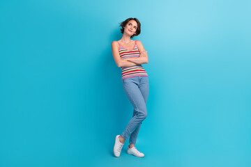 Fototapeta na wymiar Full body photo of minded creative pretty girl folded arms look empty space brainstorming isolated on blue color background