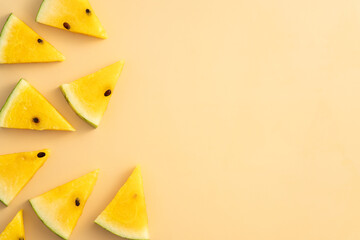 Naklejka premium Sliced yellow watermelon pattern flat lay on pastel yellow table background.