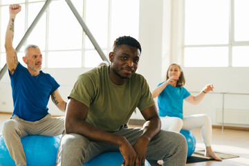 Obraz premium African American coach shows exercises with blue fitball