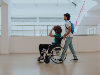 African American student pushing his friend's wheelchair through a modern school, demonstrating...