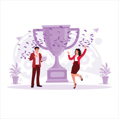 Two happy workers celebrate success in the office, with the big trophy in the background. Trend modern vector flat illustration.