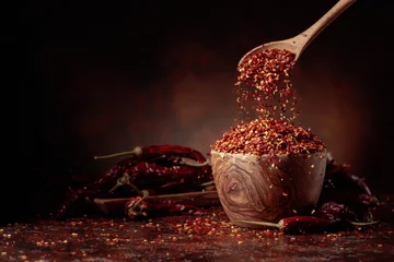Gardinen Chilischoten Chilli flakes are poured into a wooden dish.  © Igor Normann