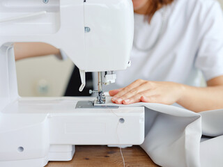 Fashion, fabric and sewing, woman at machine in small business with creative ideas and focus at home studio. Creativity, startup and design, tailor or designer stitching, young entrepreneur at work.