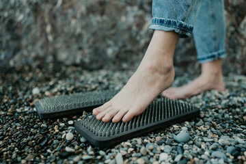 Sea Woman feet stepping on sadhu board during indian practice on the seashore. . Healthy lifestyle...