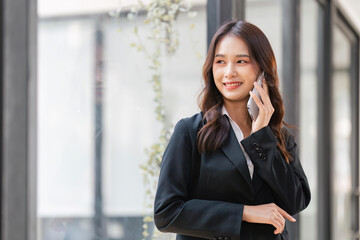 Young business woman on the phone at office. Business woman texting on the phone. Pretty young business woman sitting on workplace