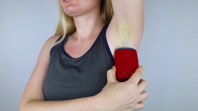 Antiperspirant containing aluminum chloride. Sweat gland blocker. Deodorant containing toxic agent. Aluminum chlorohydrate, alcohol, parabens, propylene glycol. Girl applying antiperspirant her armpit