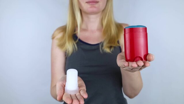 left or right. Girl chooses between eco-friendly deodorant without toxins and antiperspirant with toxic elements. In left hand Mineral alum crystal stick, in right hand classic remedy chemical nature
