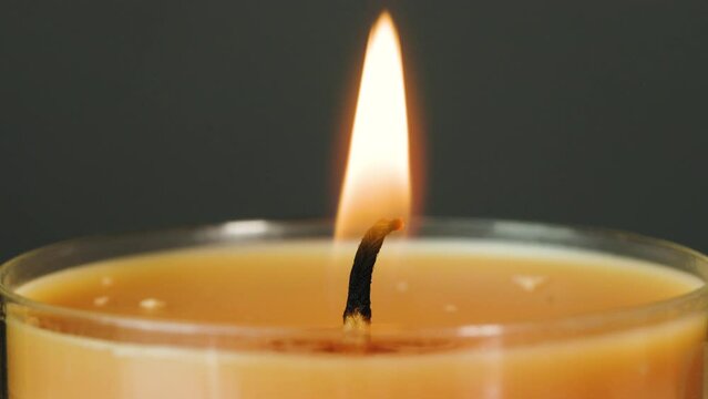 Burning match lights candle in macro