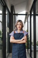 Coffee shop owner looking confident smiling at camera with arms crossed. Positive business concept