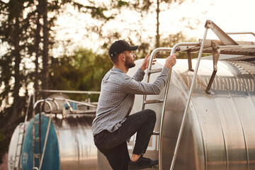 Big fuel tanker. Young truck driver in casual clothes