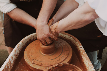 Teaching pottery to people. A master teaches a woman pottery.