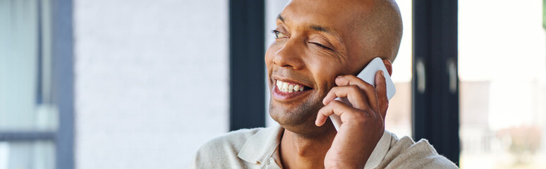 Obraz premium myasthenia gravis disease, bold african american man at work, cheerful and dark skinned office worker with ptosis syndrome talking on smartphone, inclusion, corporate culture, banner