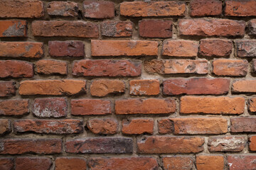 Textured red color brick wall background closeup 