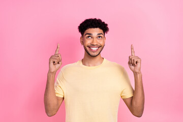Portrait of multinational cute student man direct fingers look up empty space wear shirt isolated...