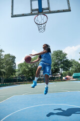 Full-length image of competitive young man in blue uniform playing basketball, throwing ball....
