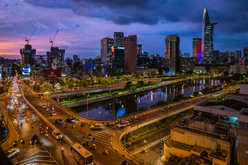 Fototapeta na wymiar Aerial view of Bitexco Tower, buildings, roads and Saigon river in Ho Chi Minh city