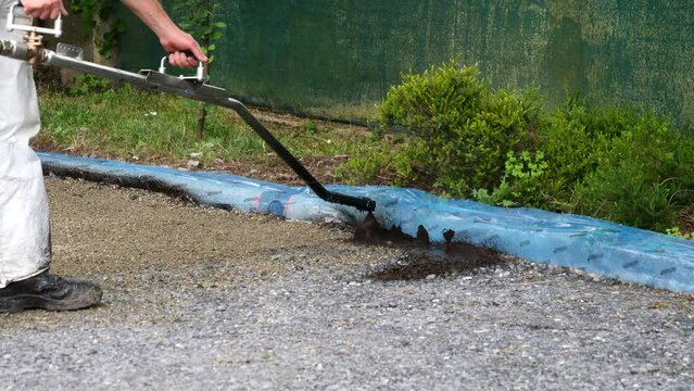 Worker lay bitumen using tar sprayer