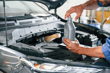 With fuel can. Auto mechanic working in garage. Repair service