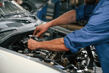Repair service. Auto mechanic working in garage - obrazy, fototapety, plakaty
