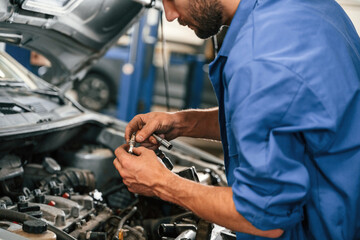 Fototapeta na wymiar Engine fix. Auto mechanic working in garage. Repair service