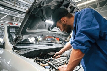 Engine fix. Auto mechanic working in garage. Repair service