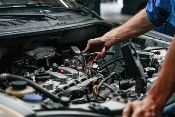 Engine fix. Auto mechanic working in garage. Repair service