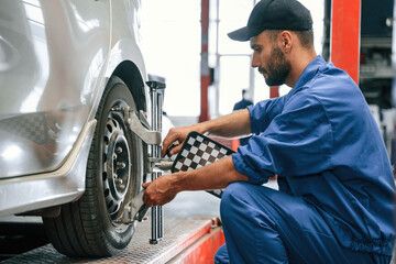 Taking care of wheel disk. Auto mechanic working in garage. Repair service