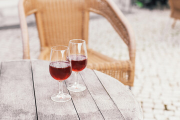 Two glasses of alcoholic beverage - Portuguese sweet wine Moscatel on a wooden table in a vineyard cafe terrace 