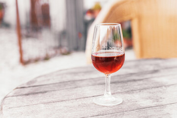 A glass of cold alcoholic beverage - Portuguese sweet wine Moscatel on a wooden table