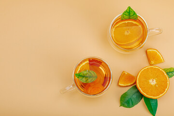 Orange tea in glass cups with ripe fruits. Refreshment seasonal drink, conceptual background