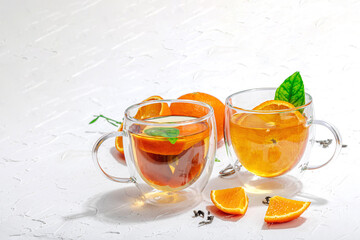 Orange tea in glass cups with ripe fruits. Refreshment seasonal drink, conceptual background