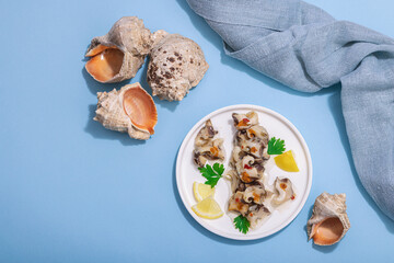 Pickled rapan meat with oil, spices and greens. Healthy seafood rich of omega