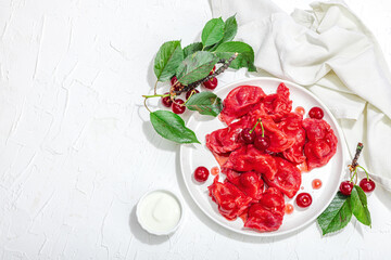 Dumplings, filled fresh cherries. Ripe fruits, sweet sauce, sour cream. Traditional Ukrainian dish