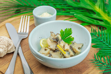 Rapana clam meat with oil, spices and greens. Healthy seafood is rich in omega. Marine decor