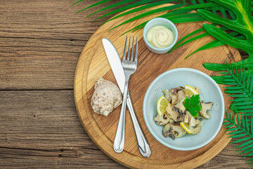 Rapana clam meat with oil, spices and greens. Healthy seafood is rich in omega. Marine decor