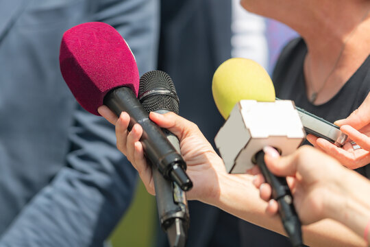 Experience the power of media as journalists with microphones gather at an event for a green agenda press conference, providing comprehensive coverage and amplifying environmental initiatives