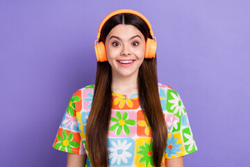 Photo portrait of pretty young girl listen music excited impressed wear trendy flower print outfit isolated on violet color background